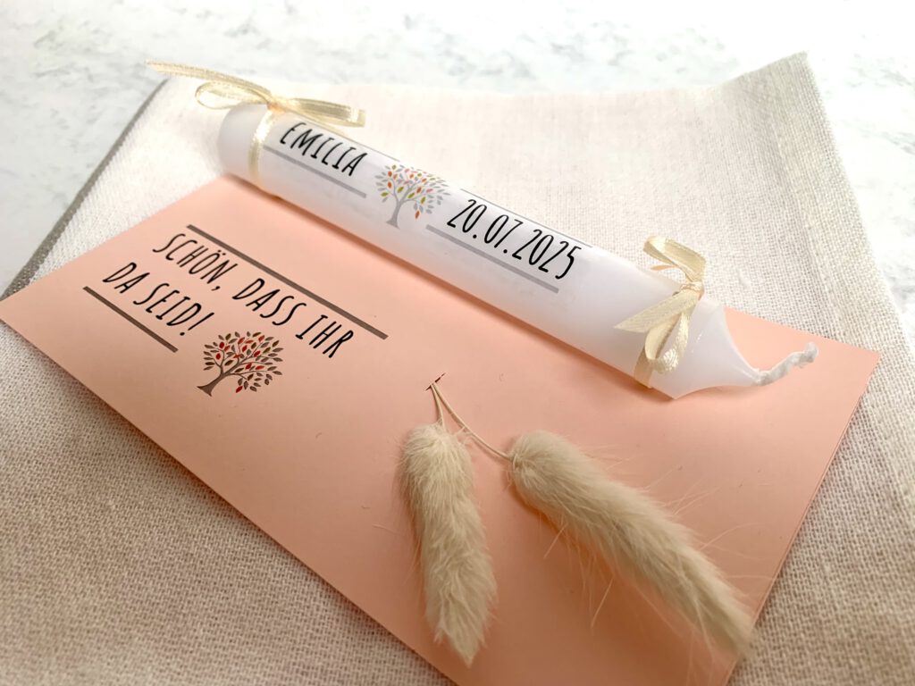 Gastgeschenk-Taufe-Kerze-mit-Name Personalisierte Mini Stabkerzen als Gastgeschenk zur Taufe selber machen: Weiße Kerze mit kleinen Schleifen befestigt auf Fotokarton. Die Kerze ist mit Wasserschiebefolie beschriftet und personalisiert.