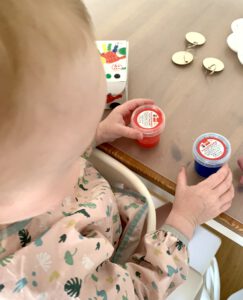 Kleinkind von hinten beim Basteln mit Fingerfarben für ein DIY Vatertagsgeschenk