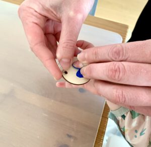 Kleinkind druckt mit Fingerfarbe ein Herz auf einen Schlüsselanhänger – Geschenkidee zum Vatertag