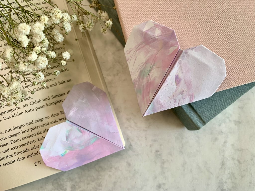 lesezeichen-als-geschenkidee Zwei herzförmige Lesezeichen, nach Origamitechnik gefaltet aus Kinderzeichnungen. Schnelle last-minute-Geschenkidee