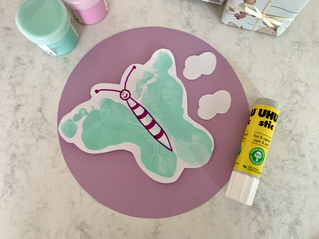 schmetterling-aus-fussabdruecken-basteln Schmetterlingsform aus Fußabdrücken wird auf Tonkarton geklebt – DIY-Karte