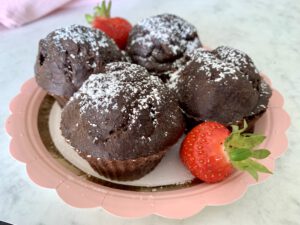 Vier Schokomuffins ohne Zucker auf einem Teller als idealer Snack für den Kindergeburtstag