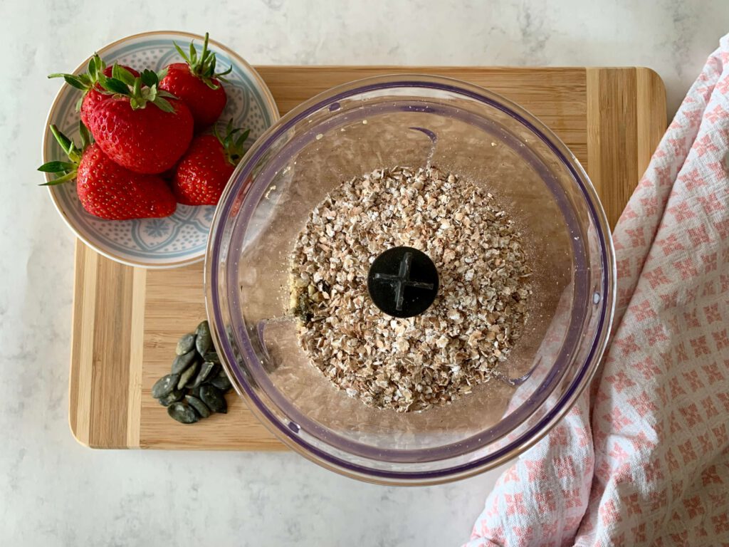 fruehstuecksbrei-selber-machen.jpg Getreideflocken als Basis für einen selbstgemachten und gesunden Frühstücksbrei für Kinder. Im Hintergrund Erdbeeren