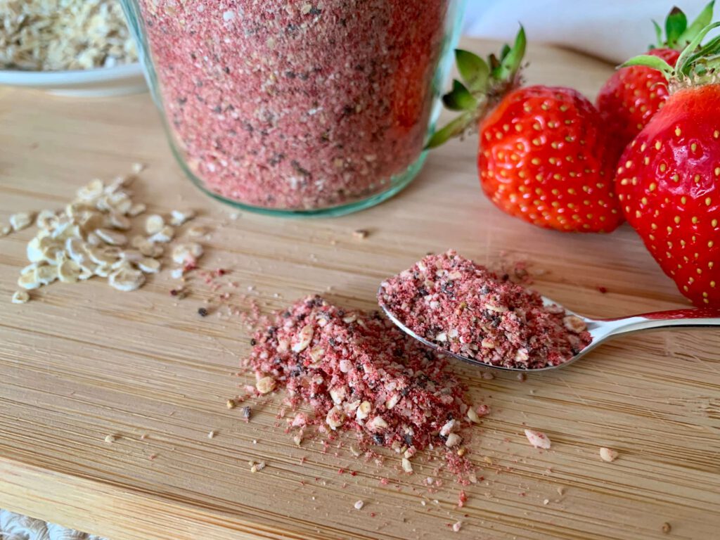 loeffel-mit-instant-porridge-pulver-vorratsglas.jpg Ein Löffel mit Instant-Porridge aus Haferflocken, Nüssen und Erdbeeren – schnelles, ballaststoffreiches Frühstück für die ganze Woche, ideal für Kinder