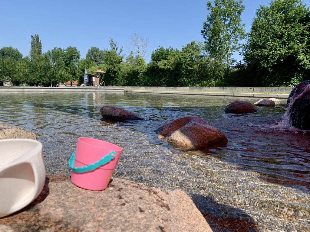 freibad-region-augsburg-fuer-kleinkinder.jpg Baby- und Kleinkinderbereich im Naturfreibad Kaufering. Große Steine laden zum Klettern ein. Sommerlicher Familienausflug zwischen Augsburg und Landsberg