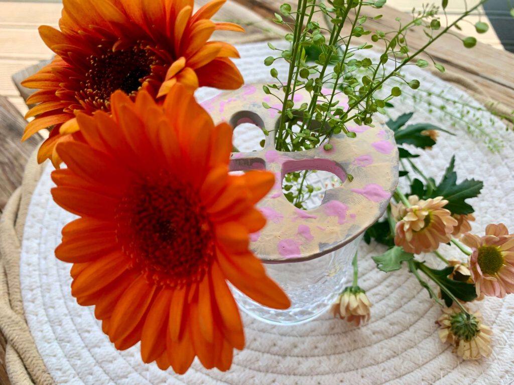 blumenretter-herzmotiv-orangene-blueten-gras.jpg Blumenretter mit Herzmotiv und orangenen Blüten – einfache Bastelidee mit Kindern