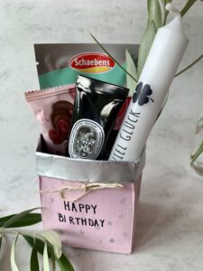Fertiges DIY Geschenkkörbchen aus Milchpackung mit Snacks und Pflegeprodukten als kleines Geschenk