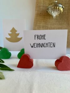 Basteln mit Kindern für Weihnachten: Selbstgemachte Fotohalter aus Modelliermasse mit eingesteckten Weihnachtskarten aufgestellt.