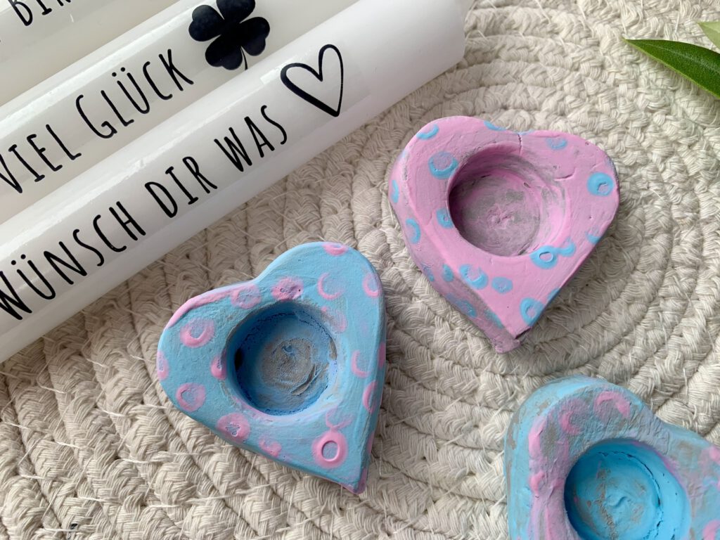 Selbstgemachte Kerzenhalter in Herzform, bunt bemalt mit Fingerfarben, kombiniert mit individuell bedruckten Kerzen. Perfekte Idee fürs Geschenke basteln mit Kleinkindern.