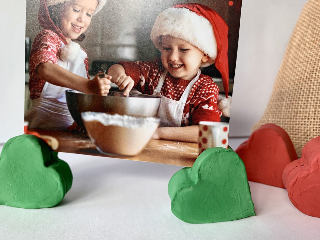 Geschenke basteln mit Kindern: Zwei grüne Fotohalter aus Modelliermasse mit einem Foto von Kindern