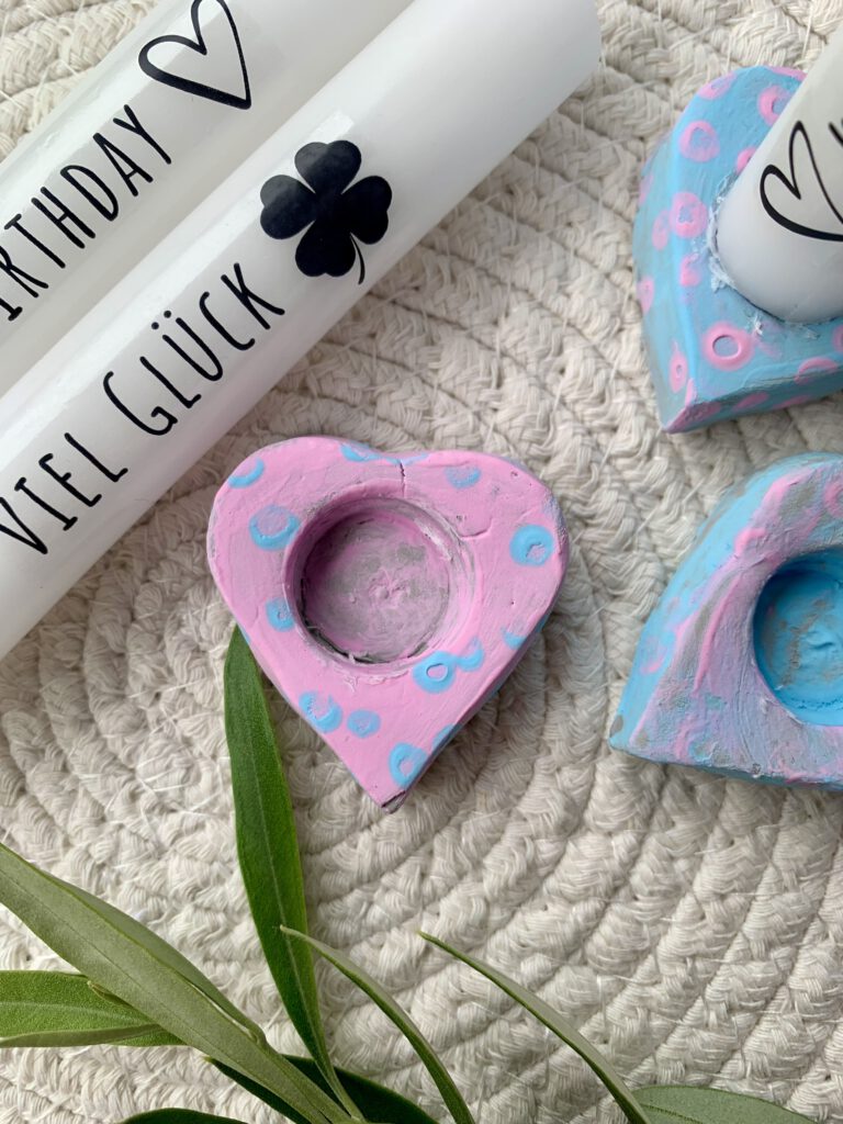 Selbst gebastelte Herz-Kerzenhalter mit Kerzentattoos, bemalt von einem Kleinkind – kreative Geschenkidee zum Muttertag oder Geburtstag.
