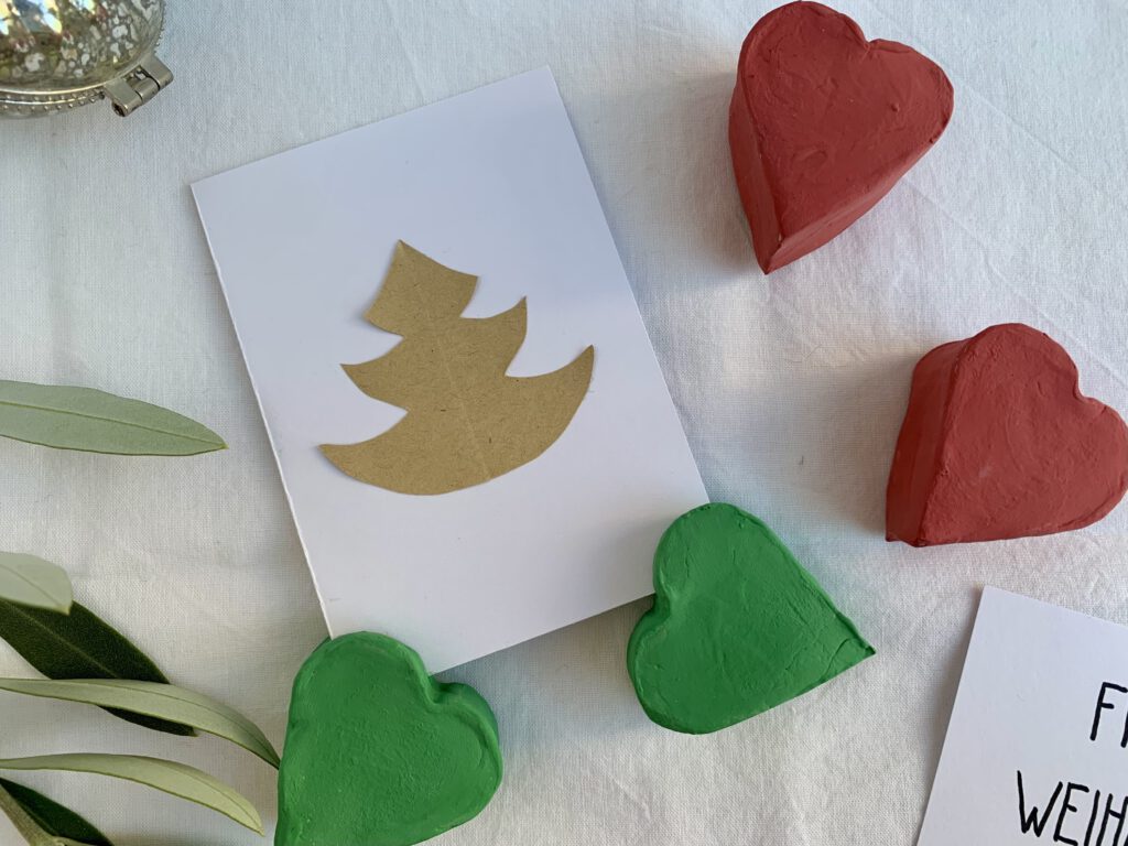 Vier Fotohalter aus Modelliermasse mit Weihnachtskarte mit Tannenbaum von oben fotografiert. Eine Geschenkidee für Weihnachten, mit Kleinkindern gebastelt.