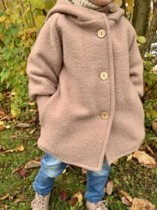 Kleinkind trägt die Wollwalkjacke von Petit Cochon im Herbst – nachhaltige, warme Kindermode aus Wollwalk.