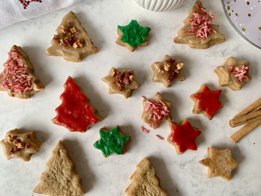 Plätzchen von oben mit drei zuckerfreien Deko-Ideen – gefärbter Mandelmus, bunte Kokosstreusel und Fruchtstreusel-Dekor