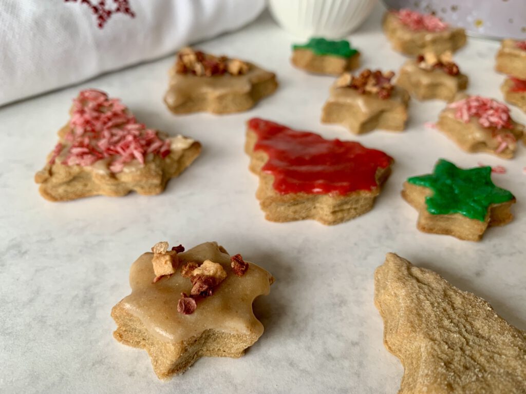 Detailaufnahme von zuckerfrei verzierten Weihnachtsplätzchen mit buntem Zuckerguss aus Mandelmus und Streuseldekor