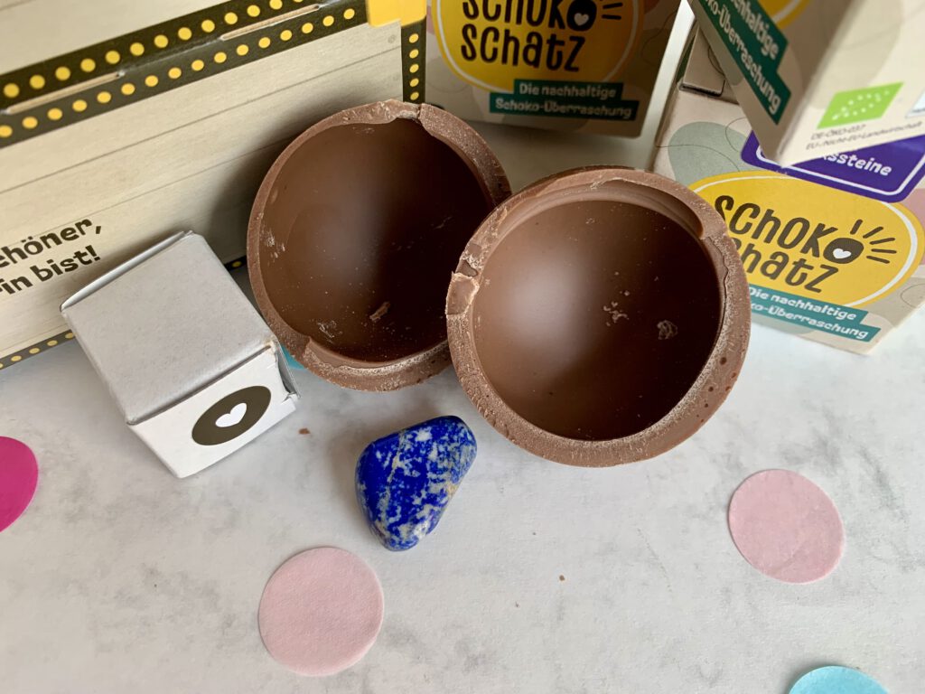 Geöffnete Schokoschatz-Schokokugel mit sichtbarem Edelstein