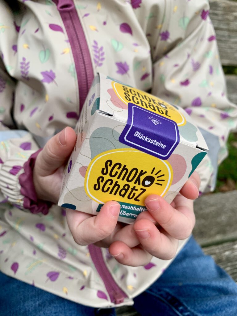 Kleinkind hält einen Schokoschatz in der Hand