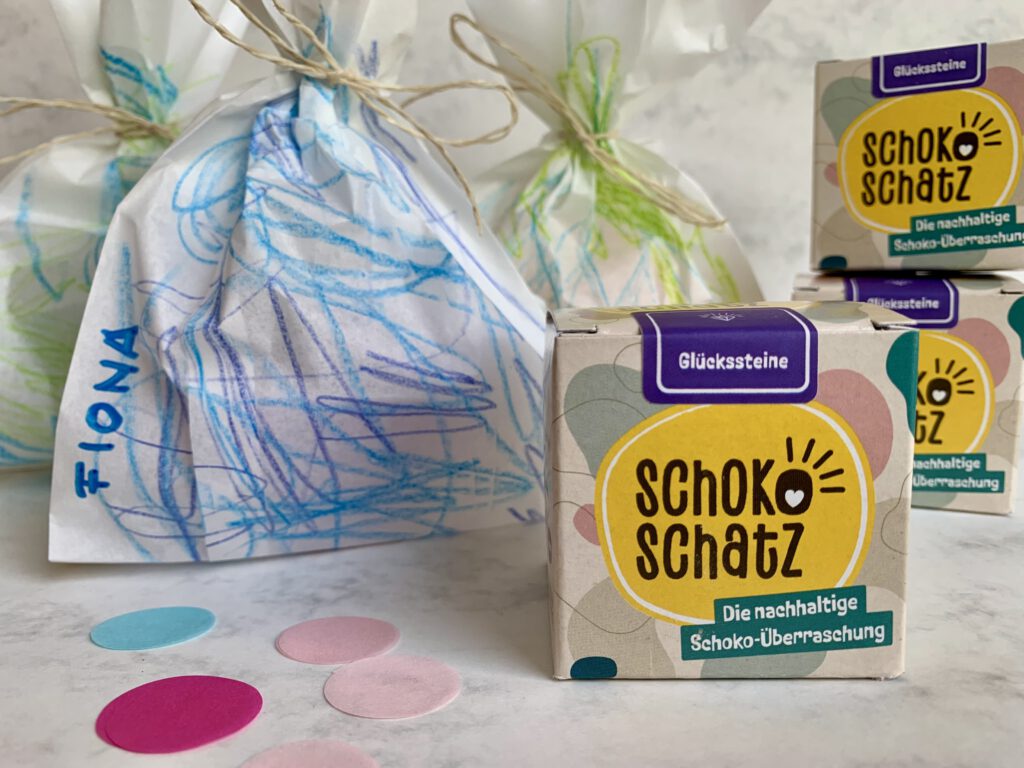 Detailaufnahme einer Schokoschatzpackung mit Geschenktüten im Hintergrund