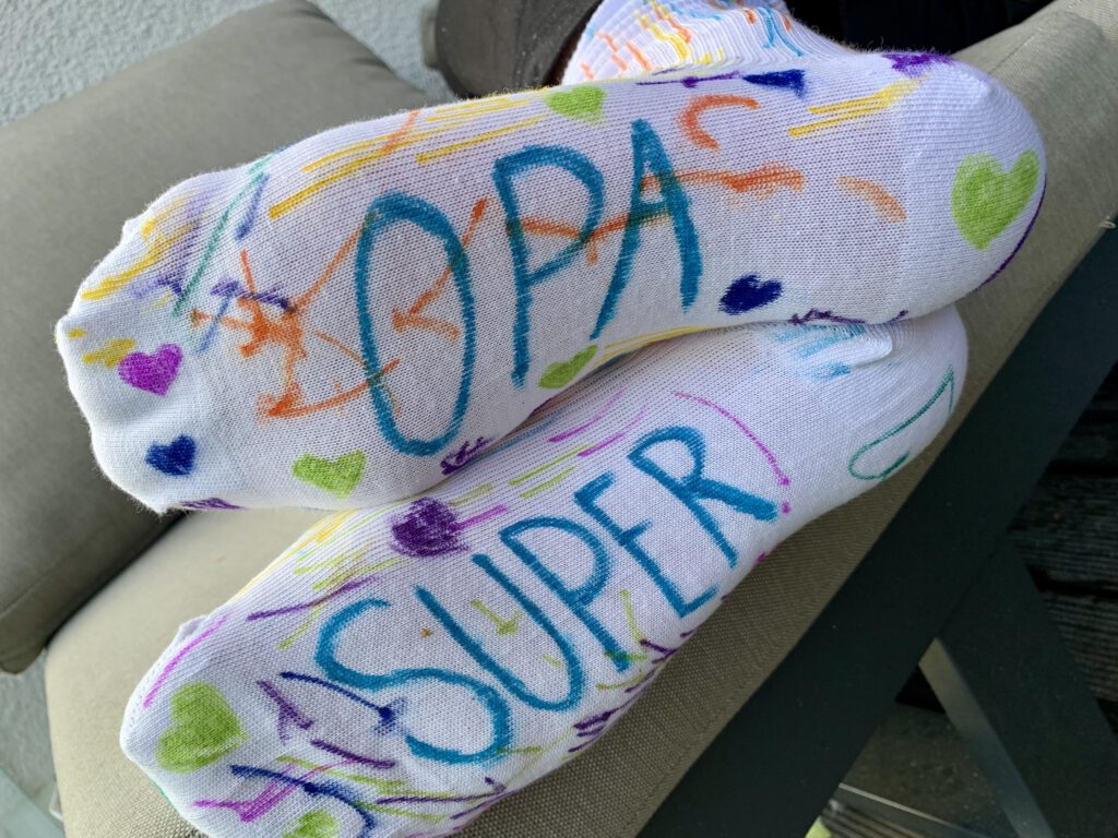 elbstbemalte Super-Opa-Socken angezogen auf der Couch – originelles DIY-Geschenk für Männer