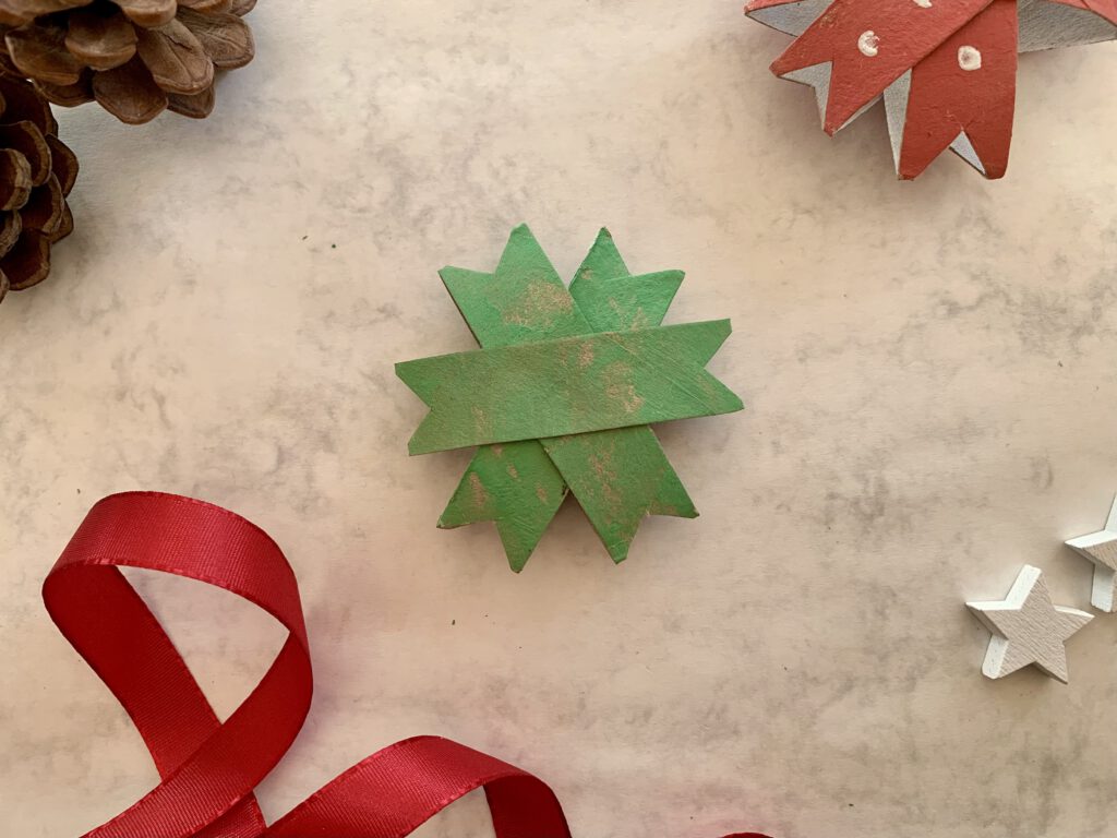 Fertig geklebter grüner Weihnachtsstern aus Toilettenpapierrollen, nachhaltige Bastelidee für Kinder.