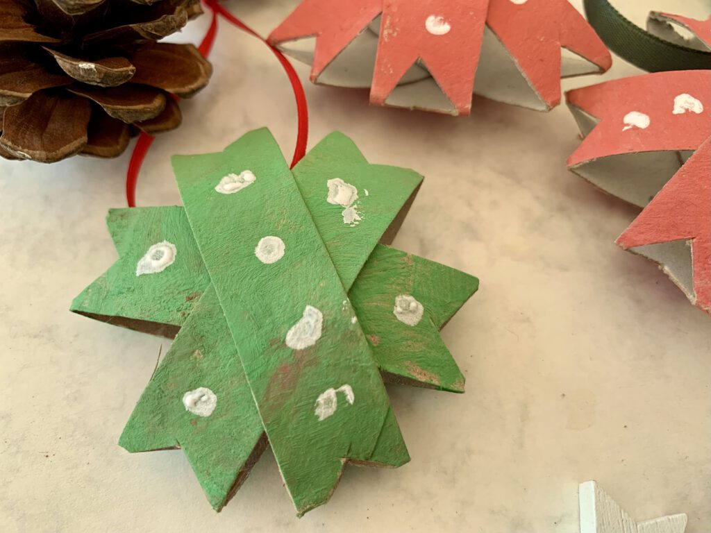 Nahaufnahme eines grünen Weihnachtssterns, im Hintergrund rote Sterne – kreative Bastelidee für Weihnachten