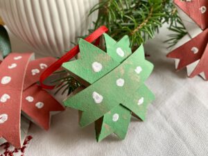 Detailfoto eines grünen Weihnachtssterns aus Klorollen mit Tannenzweig, Weihnachtsdeko zum Selbermachen.