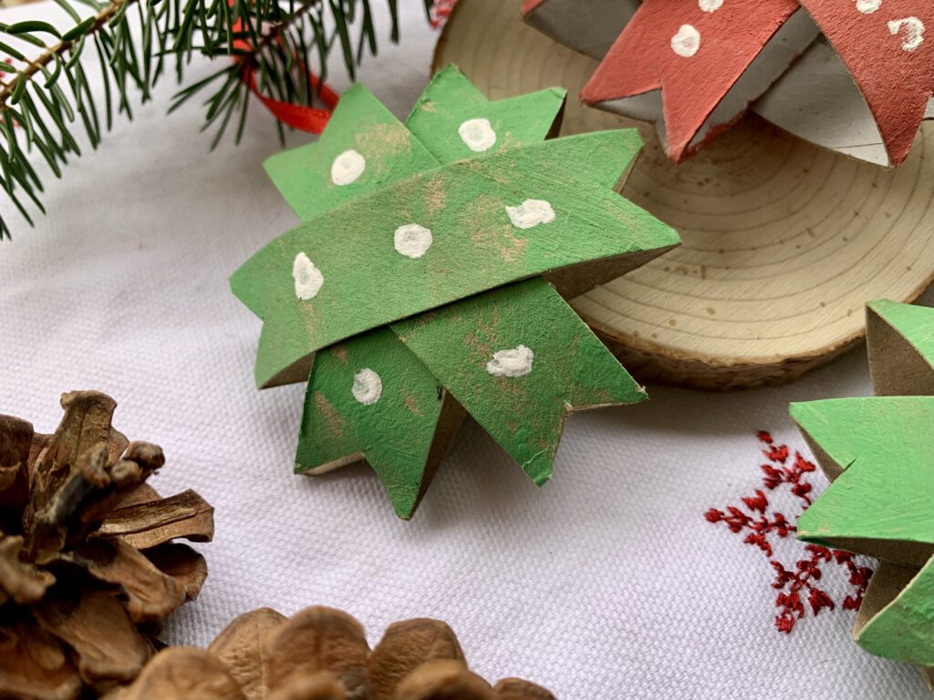 Weihnachtsstern gebastelt aus einer Klopapierrolle. Papierrolle mit grüner Fingerfarbe bemalt, in Streifen geschnitten und zu einem Weihnachtsstern zusammengeklebt. Einfache Sterne basteln mit Kindern für Weihnachten. 