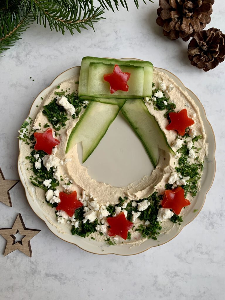 fingerfood-weihnachten-hummuskranz-einfach.jpg Einfaches weihnachtliches Fingerfood: fertig dekorierter Hummus-Kranz als herzhafte Alternative zu Plätzchen.