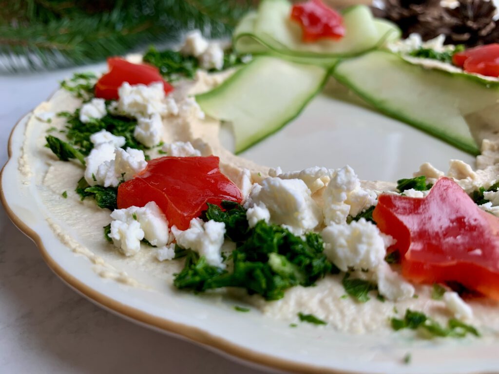 hummuskranz-paprikasterne-detail-weihnachten.jpg Detailaufnahme von roten Paprikasternen als Deko auf dem weihnachtlichen Hummus-Kranz.
