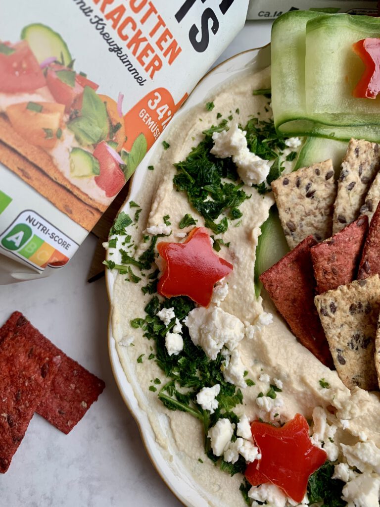 hummuskranz-detailaufnahme-weihnachtlich.jpg Detailaufnahme vom weihnachtlichen Hummuskranz mit Kräutern und Gemüse-Deko. Leckeres herzhaftes Fingerfood für Weihnachten mit Gästen.