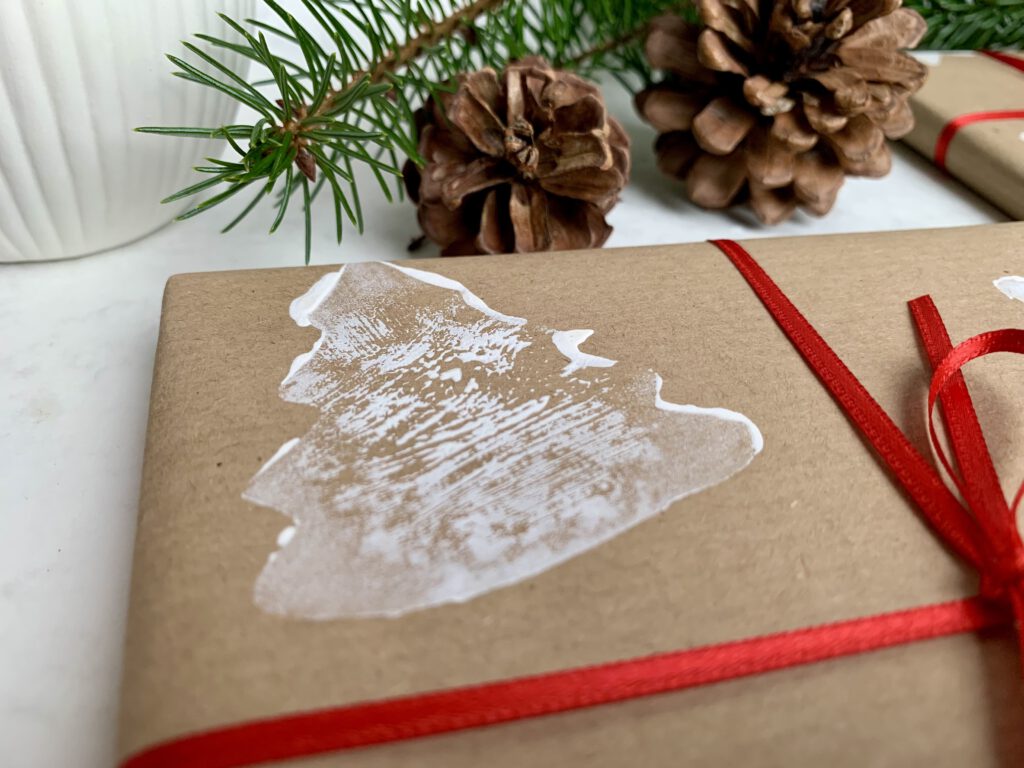 Detailbild eines Geschenks mit gestempeltem Tannenbaum auf Packpapier – weihnachtliches Geschenkpapier selber machen