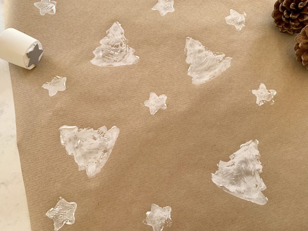 Sternenstempel und weiße Sterne auf Packpapier gestempelt – einfache Bastelidee mit Kindern