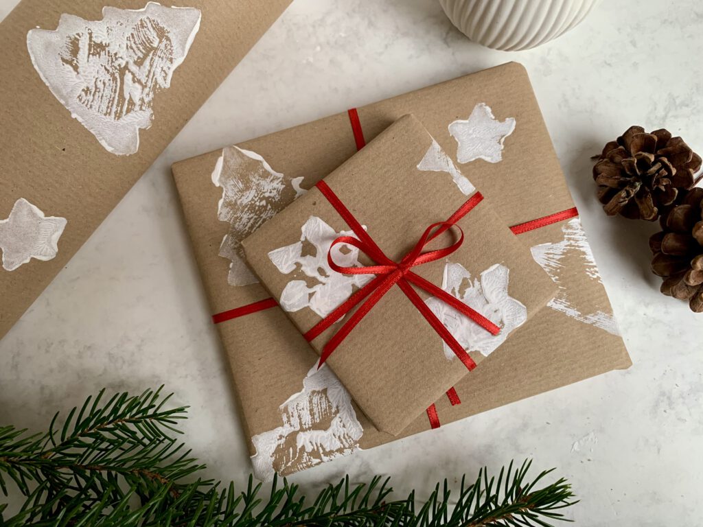 Zwei eingepackte Geschenke mit selbstgemachtem Packpapier – nachhaltige Bastelidee mit Kindern