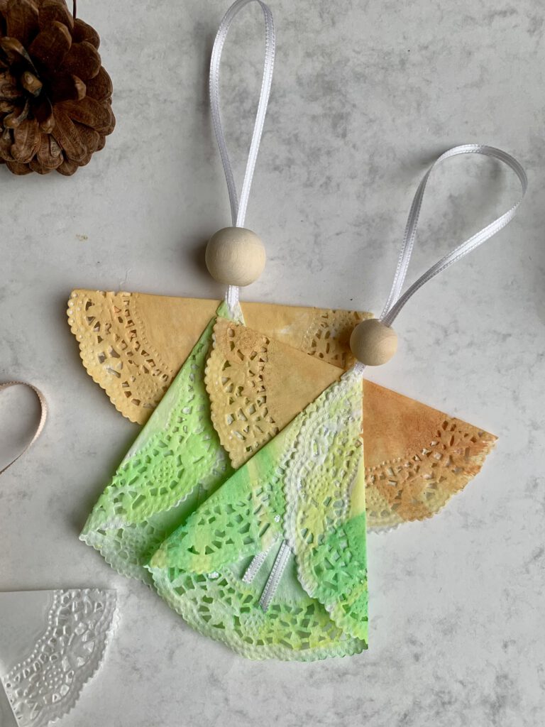 mehrere-tortenspitzen-engel-bunt-weihnachtsbasteln-kleinkinder.jpg Mehrere bunte Weihnachtsengel aus bemalter Tortenspitze, gebastelt von Kleinkindern. Last Minute Basteln für Weihnachten