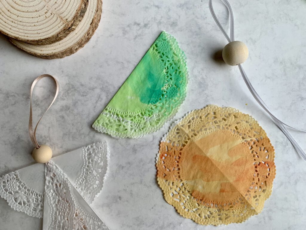 tortenspitze-fluegel-engel-basteln-mit-kindern.jpg Halbierte Tortenspitze wird zu Flügeln für einen selbst gebastelten Weihnachtsengel.