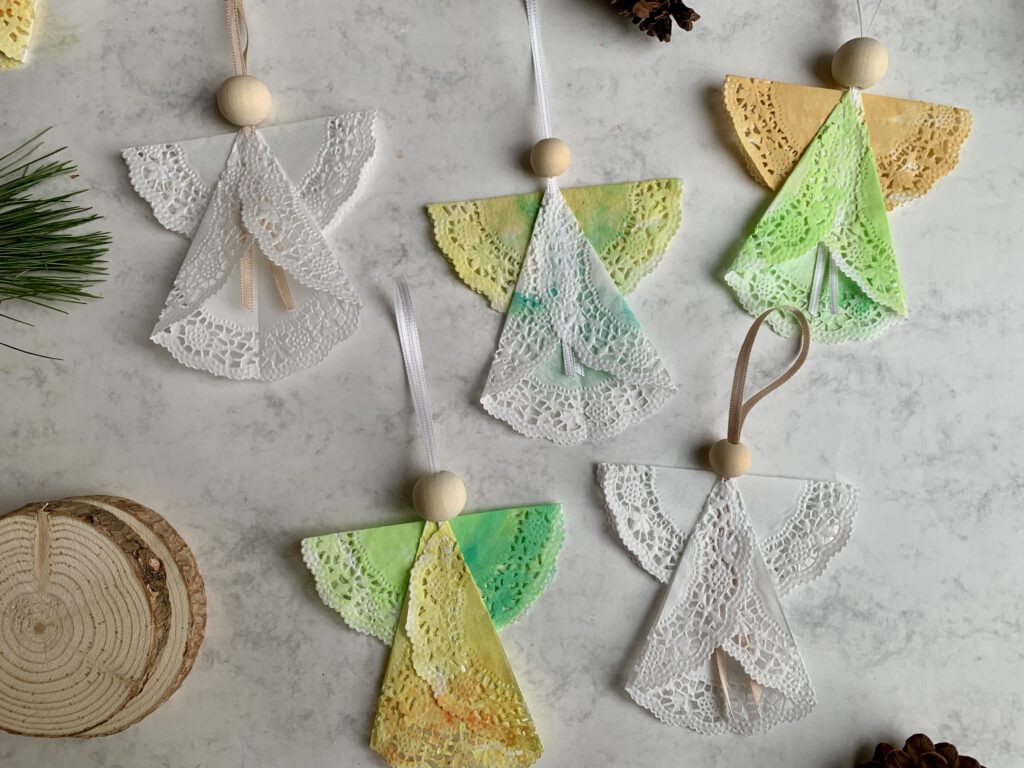 tortenspitzen-engel-gruppe-weihnachtsdeko-diy-mit-kindern.jpg Eine Gruppe selbst gebastelter Tortenspitzen-Engel als weihnachtliche Dekoration. Einfache Bastelidee zu Weihnachten mit Kleinkindern.