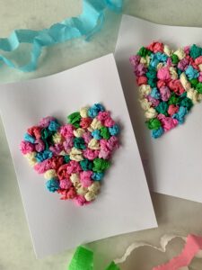 Zwei fertige Herzkarten mit bunten Papierkügelchen aus Krepppapier – einfache Knülltechnik zum Karten basteln mit Kleinkindern