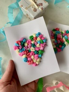 Hand hält eine selbst gebastelte Herzkarte – einfache Kartenidee zum Basteln mit Kleinkindern ab 2 Jahren