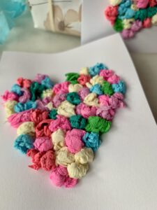 Detailaufnahme einer Herzkarte mit Krepppapierkügelchen – einfache Bastelidee für Kleinkinder