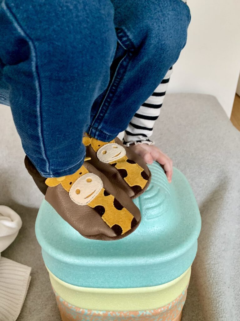 Kleinkind trainiert Balance und Fußmuskulatur mit Pantolinos Kita-Hausschuhen