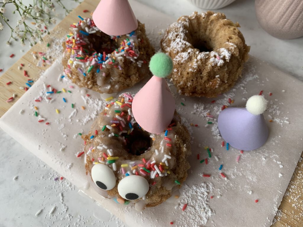 Kreative Muffin-Deko für Kindergeburtstag mit bunten Streuseln und rosa und lila Partyhut