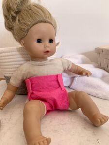 puppenwindel-aus-filz-pink.jpg Sitzende Puppe mit pinker Puppenwindel aus Filz ohne Nähen