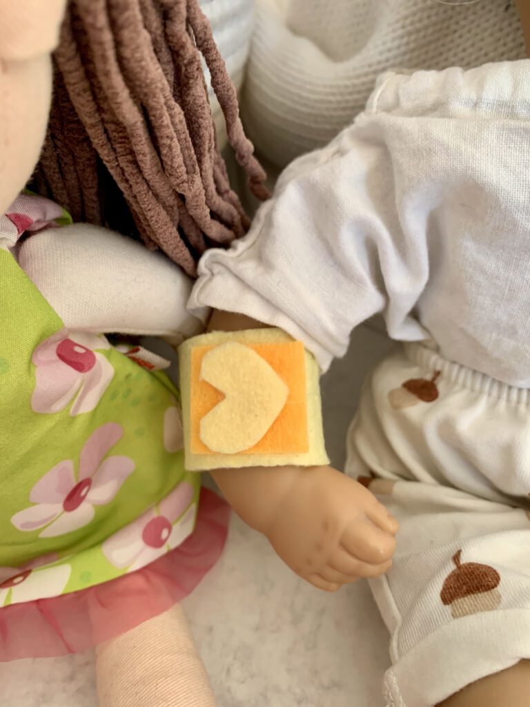 Detailaufnahme eines Puppenpflasters ohne Nähen mit Herz-Deko aus Filz