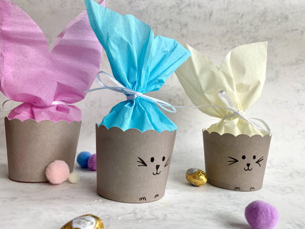 Rückseite eines Osterkörbchens mit rosafarbenen Ohren und Pompom-Schwänzchen. Geschenkidee für Ostern zum selber machen.