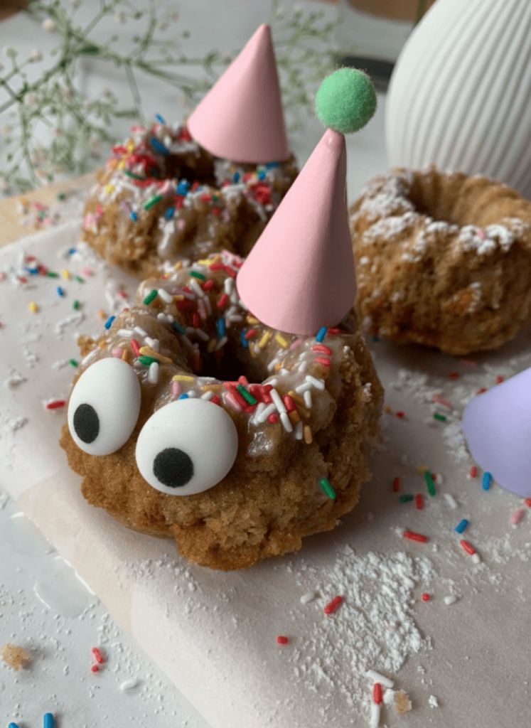 Geburtstagsmuffins für Kinder mit selbstgebastelten Partyhüten in Rosa