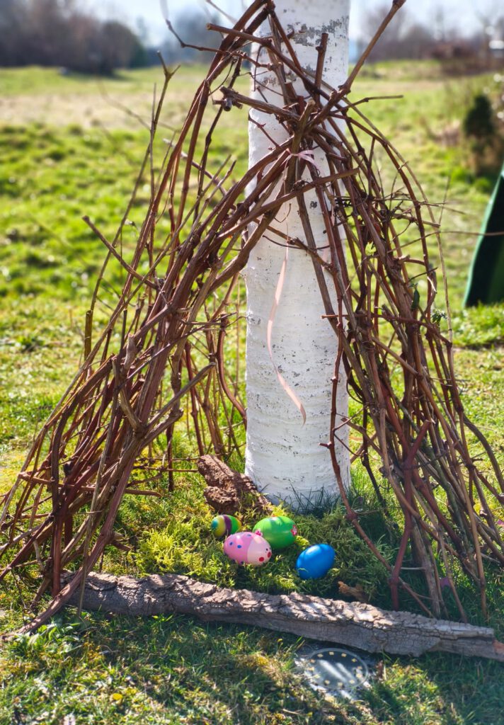 osternest-im-garten-mit-bunten-ostereiern Osternest im Garten aus Zweigen mit bunten Ostereiern