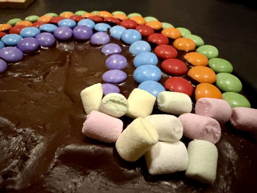 Regenbogen aus Smarties auf einfachem Schokokuchen für den Kindergeburtstag
