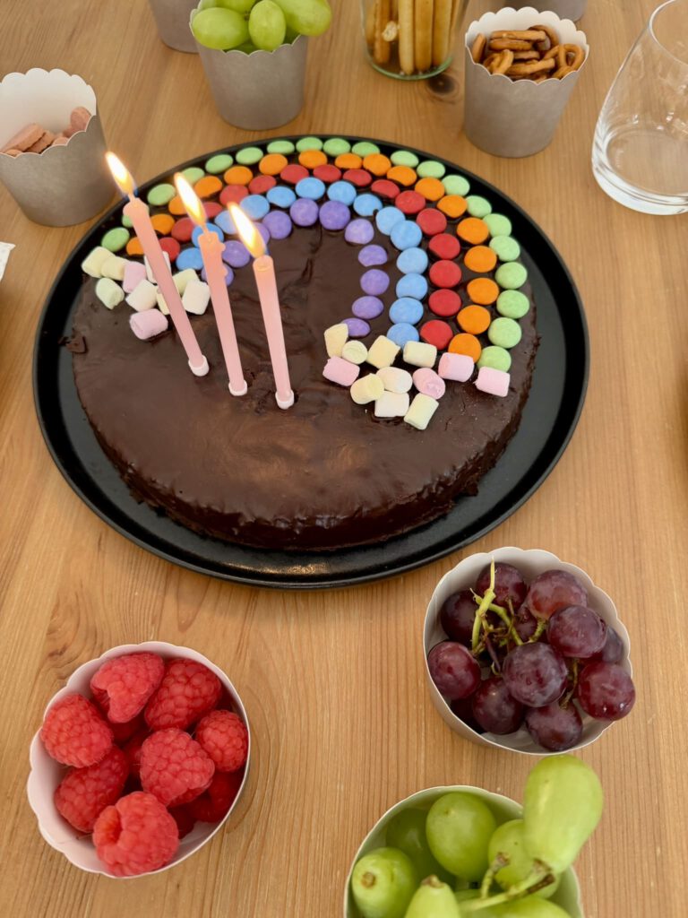 Schokokuchen mit Kerzen und Regenbogen für den Kindergeburtstag