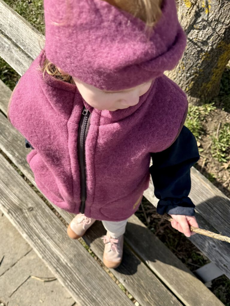 Detailaufnahme von Wollfleeceweste und Stirnband aus Merinowolle für Kinder